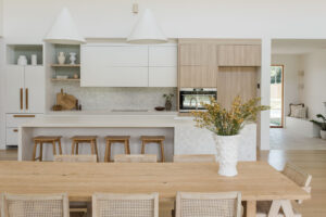 Looking through an open plan dining room through to the oak and stone kitchen.