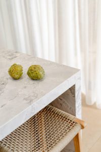 A close up of a stone bench top featuring custard apples.