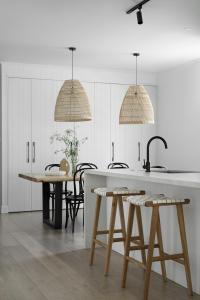 A kitchen and two pendants hang over a dining table.