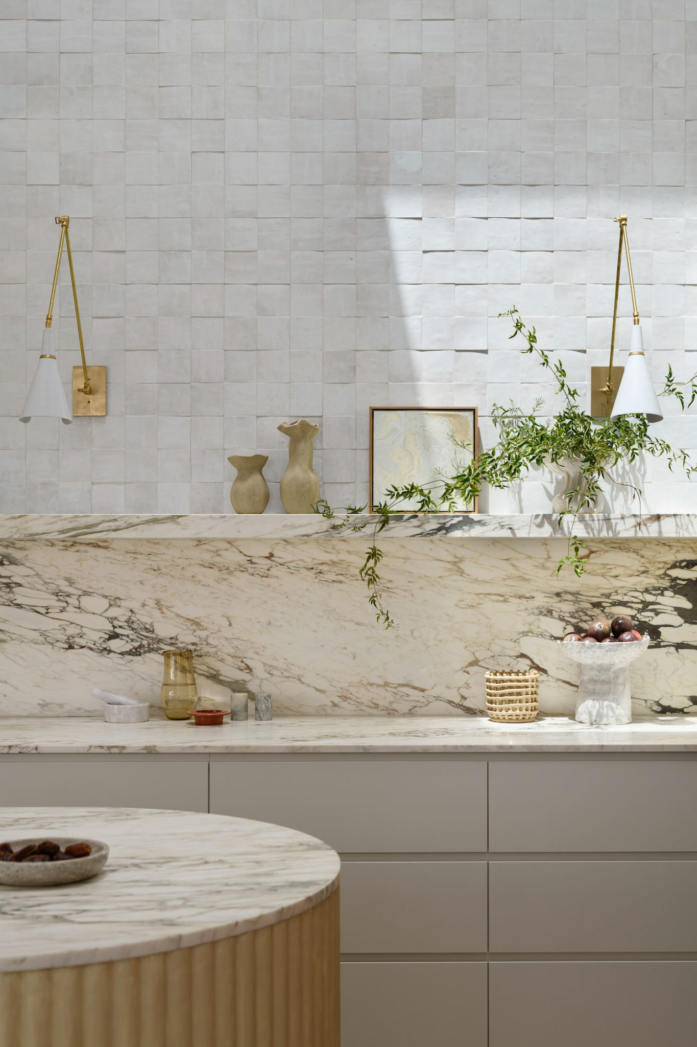 A modern kitchen with a marble backsplash, and styled open shelving.