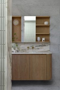 A modern bathroom styled with marble and brass details.