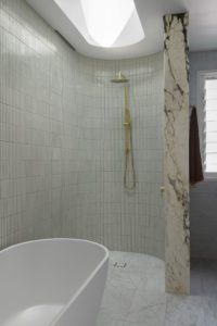 A modern bathroom styled with marble and brass details.