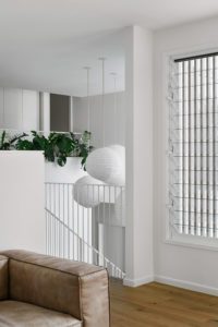 A modern Queenslander styled with large rice paper lanterns hanging over the stairs.