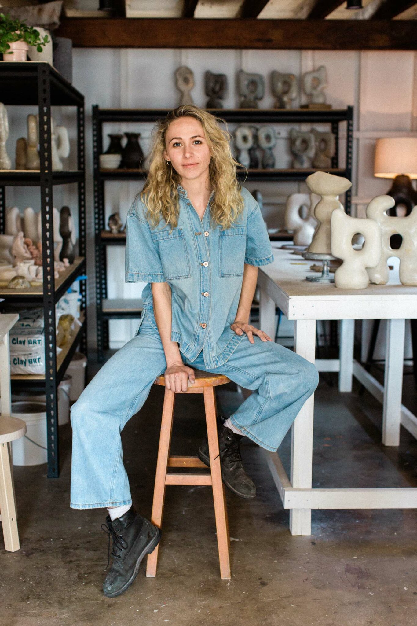 Tess sitting on a stool in her studio.