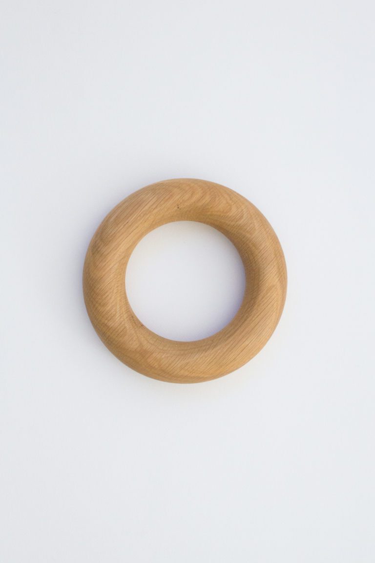 A round doughnut shaped object handmade from American Oak for styling coffee tables.