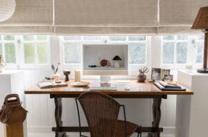 An antique table with rattan chair in a Queenslander Studio.