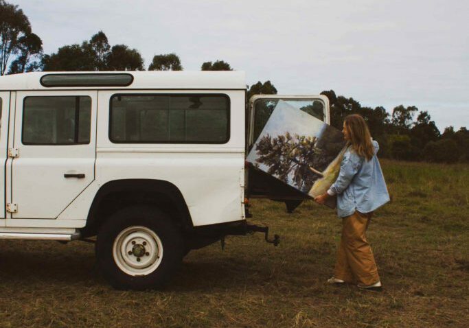 Artist unloads artwork from the back of a Defender Land Rover.